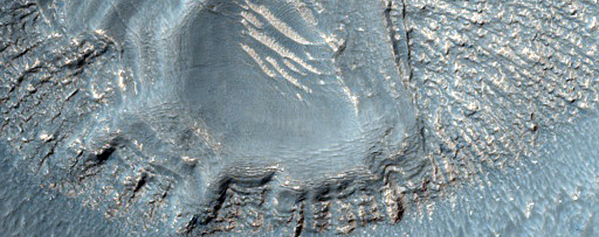 Layered Features in Crater in Promethei Terra