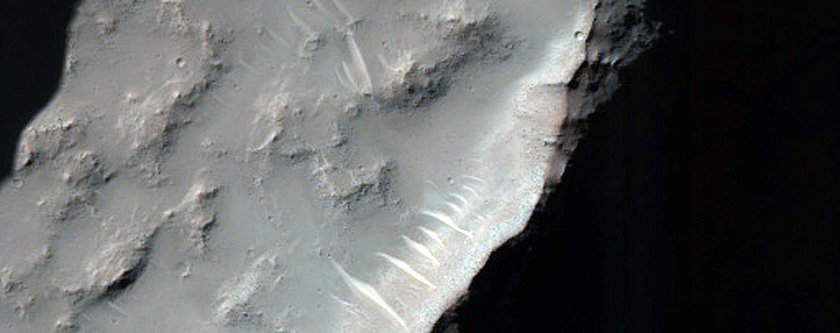 Possible Hydrated Materials on Rim of Crater in Thaumasia Planum