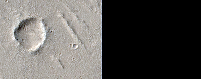 Pitted Materials Flowing off Rampart of Elliptical Crater