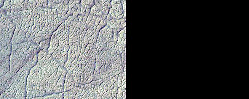 Icy Terrain with Polygonal Fractures in and around Craters